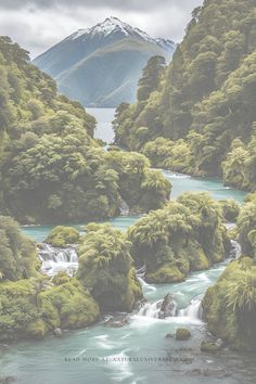 a river surrounded by lush green trees and mountains