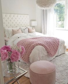 a bedroom with pink and white decor on the walls, carpeted flooring and bedding