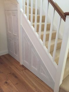 an empty room with wooden floors and white stairs