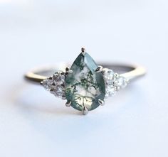 Best seller at Capucinne - A delicate marquise engagement ring features teal sapphire with side diamonds. A beautiful genuine teal - green sapphire complimented with diamonds to create a simple yet stunning ring. Please click for larger Moss Agate Engagement Ring White Gold, Pear Moss, Forest Weddings, Agate Wedding Ring, Green Quince, Az Wedding, Moss Agate Jewelry, Witch Room, Moss Agate Engagement Ring