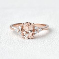 an oval morganite and diamond ring on a white surface