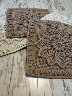 three crocheted placemats sitting on top of a wooden floor