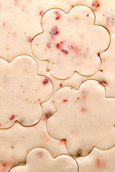 some cookies are laying on top of each other in the shape of floweres and hearts