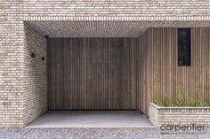 a brick building with a wooden door and planters on the outside wall in front of it