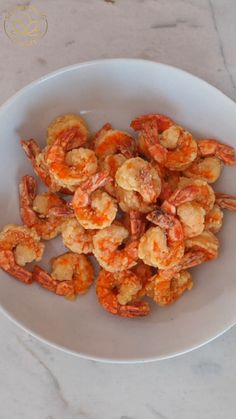 a white bowl filled with shrimp on top of a table