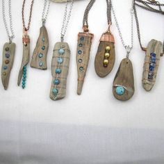 a group of wooden necklaces hanging from chains