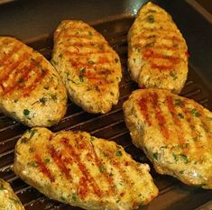 some meat patties are cooking on a grill