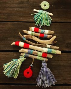 a christmas tree made out of sticks and yarn on top of a wooden table next to a ball of string