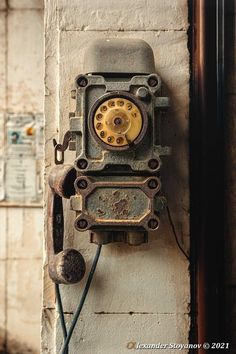 an old clock is attached to a wall with wires and plugs on it's side