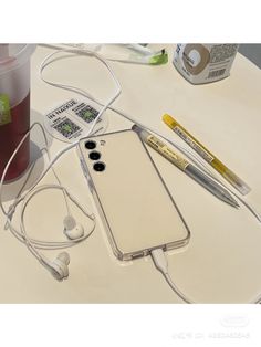 a cell phone sitting on top of a table next to ear buds