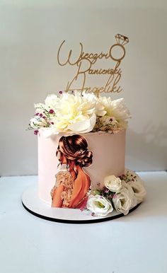 a wedding cake decorated with flowers and a bride's portrait on top is shown