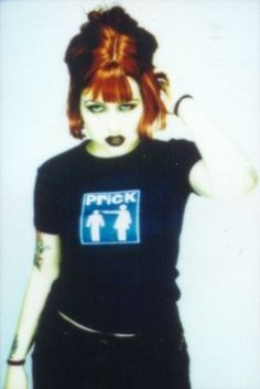 a woman with red hair and piercings is wearing a black shirt that says punk