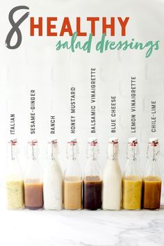 six bottles with different sauces in them on a white counter top, labeled healthy salad dressings