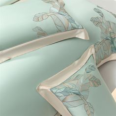 the comforter is made up with blue and beige leaves on it, along with matching pillow shampoos