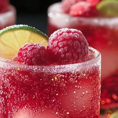 two glasses filled with raspberry lemonade and limeade garnished with sugar