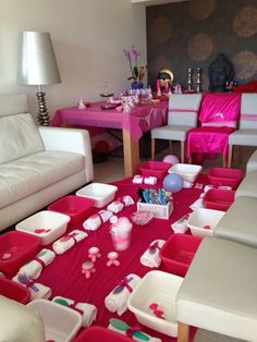 a living room filled with white furniture and pink accessories on top of a red table