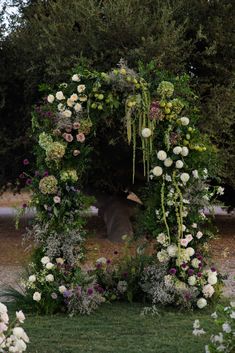 an outdoor wedding ceremony with flowers and greenery