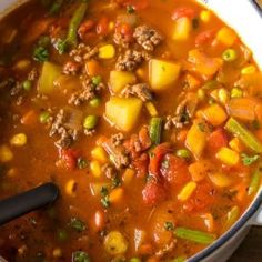 a pot filled with soup and vegetables on top of a stove