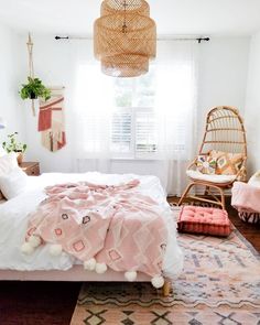 a bedroom with a bed, rugs and hanging lights in it's corner