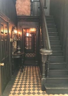 an entry way with black and white checkered flooring, two tables on either side