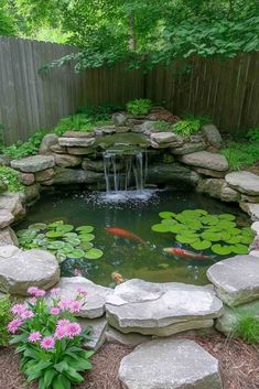 a small pond with some water lilies and rocks in the middle, surrounded by flowers