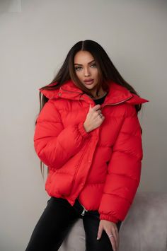 Stay warm and stylish this season with the Oversize Women's Puffer, the ultimate winter essential. Designed with a roomy, oversize cut, this puffer jacket combines both comfort and modern flair. Its high collar and voluminous hood offer extra protection from the cold, while the sleek midi jacket length ensures full coverage without compromising on movement. Crafted from waterproof fabric and filled with eco-friendly puff insulation, this women's puffer is ideal for chilly days, with a temperatur Trendy Puffer Outerwear For Cold Weather, Trendy Puffer Jacket For Cold Weather, Trendy Winter Puffer Outerwear, Trendy Solid Color Winter Puffer Jacket, Red Puffer Jacket With Pockets, Red Long Sleeve Winter Outerwear, Trendy Oversized Red Outerwear, Casual Red Outerwear For Cold Weather, Casual Red Winter Outerwear