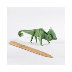 an origami dragon next to a bamboo stick