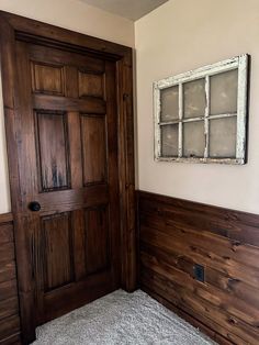 an empty room with wood paneling and a window on the wall above the door