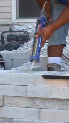 a man using a paint roller to fix a fire hydrant on the side of a house