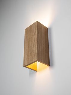 a wooden light that is on the wall next to a white wall with no one in it