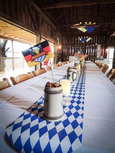 a long table is set up with two mugs on it and flags in the middle