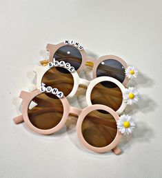 three pink sunglasses with white flowers on them