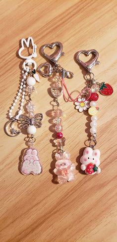 three key chains with charms attached to them sitting on a table next to each other