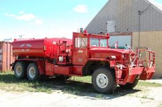 a large red truck parked in front of a building