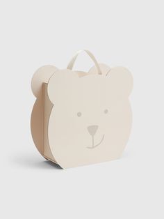 a small white bag with a bear face on the front and sides, sitting on a gray surface