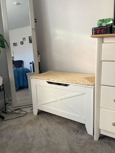 a white dresser with drawers and a clock on top