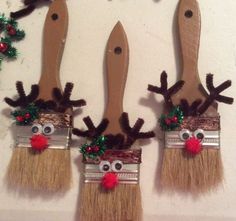 three wooden spoons with fake reindeer's on them are hanging from the wall