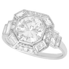 A stunning, fine and impressive contemporary 2.58 carat diamond and platinum Art Deco style dress ring; part of our diverse diamond jewelry collections. This stunning, fine and impressive Art Deco style diamond ring has been crafted in platinum. The millegrain ornamented setting features a 1.90 Ct modern brilliant round cut diamond collet set to the centre of a halo ring design. The halo style border is embellished with twelve claw set modern brilliant round cut diamonds, accented with a baguette cut diamond to each corner. Each of the ring shoulders are embellished with two collet set baguette cut diamonds, graduating in size. This impressive engagement ring has been independently tested using state of the art technology (Niton XL2 Analyzer) and verified as platinum. The ring is supplied 5 Carat Diamond Ring, Engagement Ring Art Deco, Antique Silver Jewelry, Platinum Engagement Ring, Contemporary Ring, Ring Art Deco, Platinum Engagement Rings, Estilo Art Deco, Antique Engagement Rings