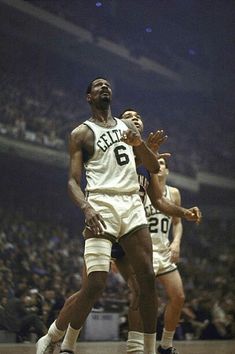 two men playing basketball in front of an audience