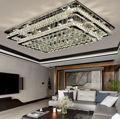 a living room filled with furniture and a large chandelier hanging from the ceiling