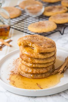 a stack of cinnamon sugar cookies sitting on top of a white plate next to some cinnamon sticks