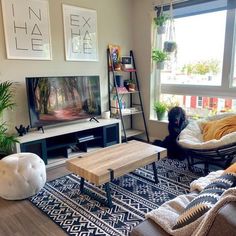 a living room filled with furniture and a flat screen tv on top of a wooden table