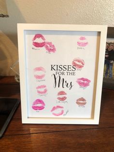 a white frame with pink lipstick kisses for the mrs on it