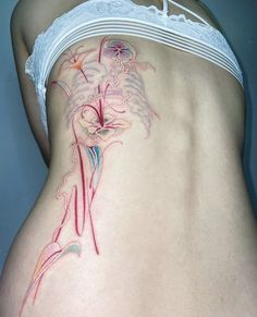 a woman's lower back tattoo with flowers on it