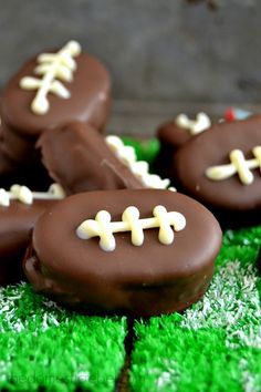 chocolate covered football cookies sitting on top of green grass