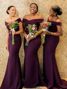 three women in long purple dresses standing next to each other and smiling at the camera