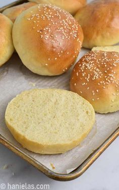 bread rolls on a baking sheet with sesame seeds