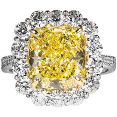 This fancy intense yellow cushion cut diamond is offered by Shreve, Crump & Low. This fancy intense yellow cushion cut diamond is custom set in a handcrafted Shreve, Crump & Low platinum and 18 karat yellow gold diamond cluster ring consisting of 1 cushion cut yellow diamond weighing 4.74 carats with color and clarity of Fancy Intense Yellow SI1 accompanied by GIA report No. 2145018498. The 4.74 carat center diamond is accented by a frame of 14 round brilliant cut diamonds with a total weight of 2.10 carat, with a color and clarity of G-H, VS1-VS2 respectively. The setting is a ring size 6.5, and is stamped with our maker's hallmark "SC&L" "PLAT" "18k" on inside of ring shank. Shreve, Crump & Low is one of America's oldest and most prestigious jewelry and fine gift establishments founded i Cushion Cut Diamond Ring, Emerald Cut Diamond Ring, Yellow Diamond Rings, Fancy Yellow Diamond, Engagement Ring Diamond Cut, Stunning Engagement Ring, Radiant Cut Diamond, Beautiful Engagement Rings, Cushion Cut Diamonds