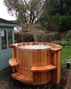 a wooden hot tub sitting next to a tree