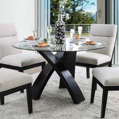 a glass table with four chairs around it